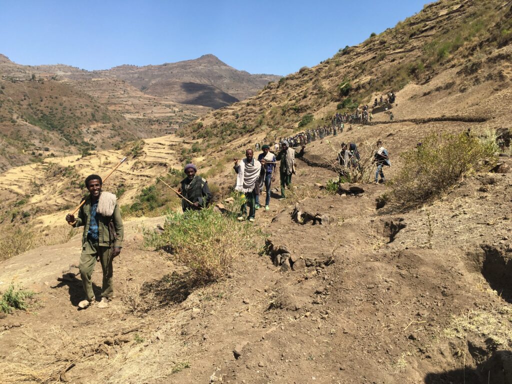 A group of people walking up a hillside in Ethiopia