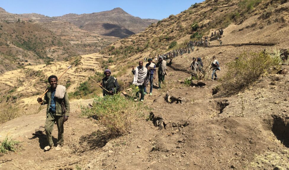A group of people walking up a hillside in Ethiopia