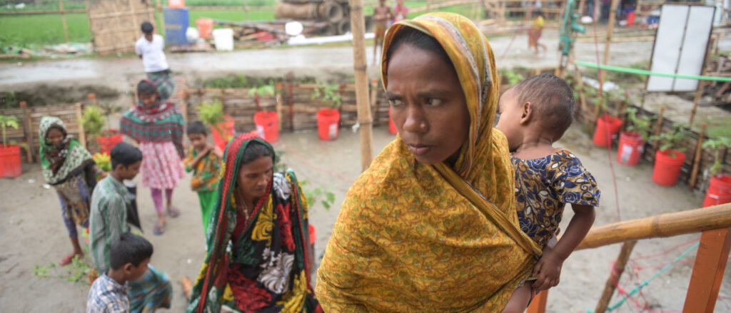 Woman carrying a child up stair to her house in Bangladesh