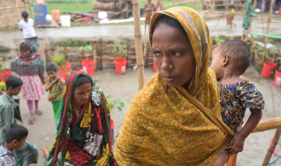 Woman carrying a child up stair to her house in Bangladesh