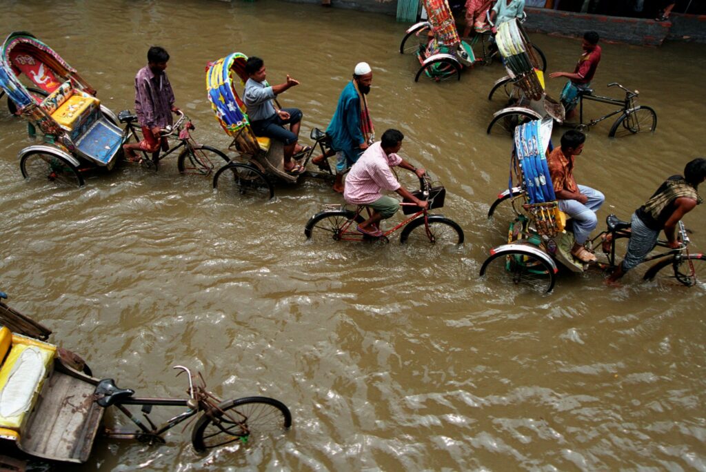 People biking through a flooded street