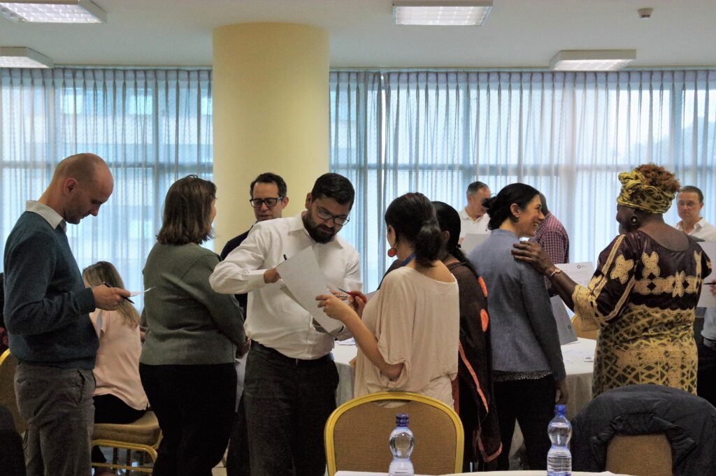 A group of people talking to each other and filling out a form together.