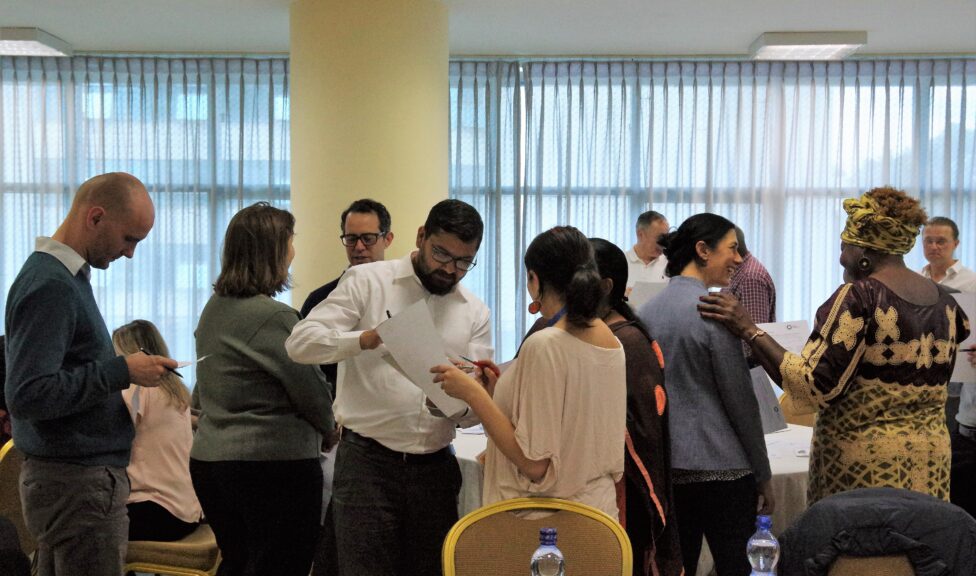 A group of people talking to each other and filling out a form together.